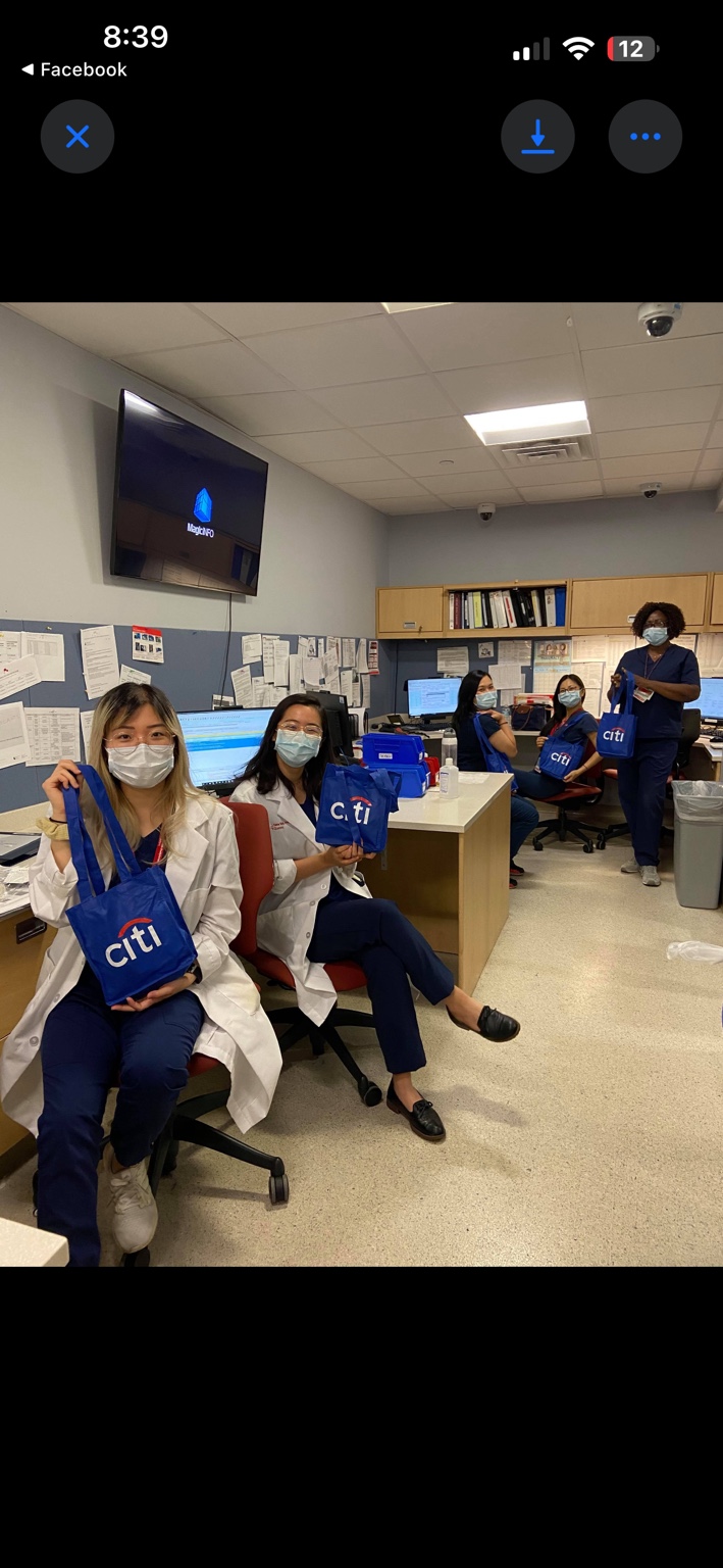 Five healthcare workers in a clinical office holding blue Citi care bags