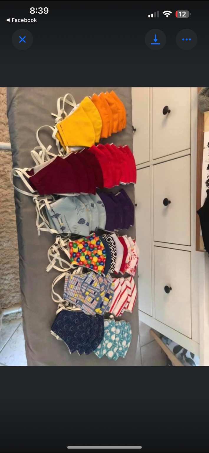 Rows of handmade cloth masks in solid colors and patterned fabrics