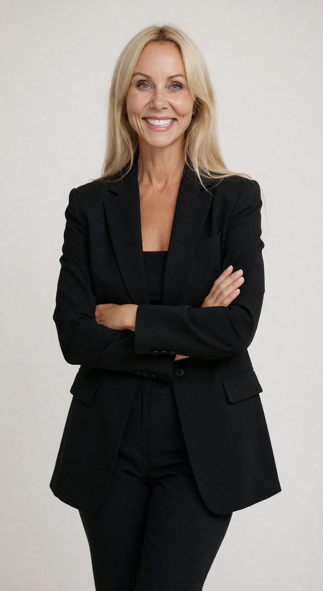 Lisa Zahakos, PA-C, founder of HEART RESERVE, smiling toward the camera in a black suit